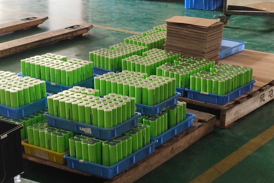 Trays of Grade-A cylindrical LiFePO4 battery cells undergoing capacity grading and BMS integration.
