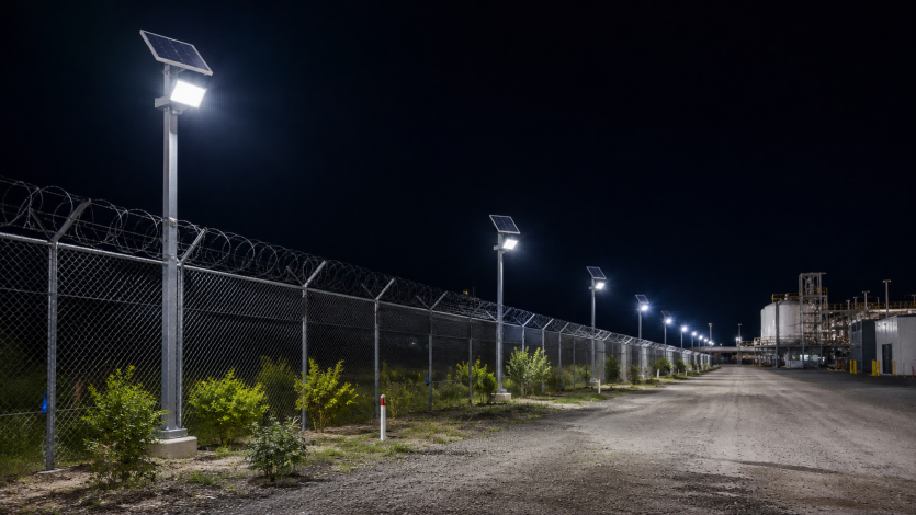 Off-grid security solar flood light mounted on fence line post for perimeter intruder deterrence featuring Quasar QSKZ-AL-3030.